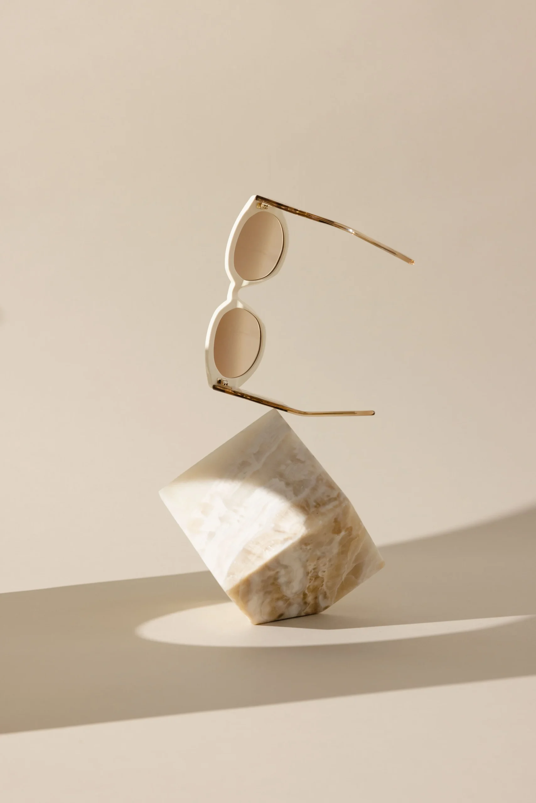 Sunglasses Floating Over Beige Marble Cube